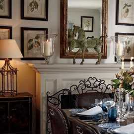 Mirror surrounded by decorative prints on a fireplace