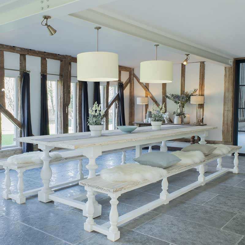 Photo of white dining table with cream lampshades cream and blue cushions