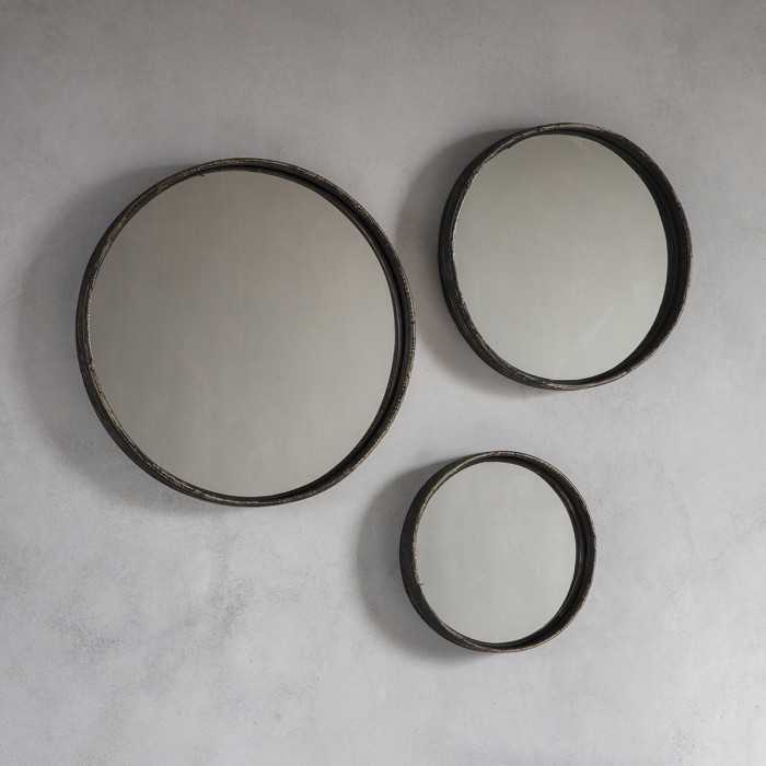 Plain round black mirrors grouped together on the wall
