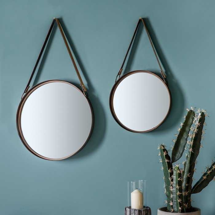 Hanging by straps round mirrors in collection on wall