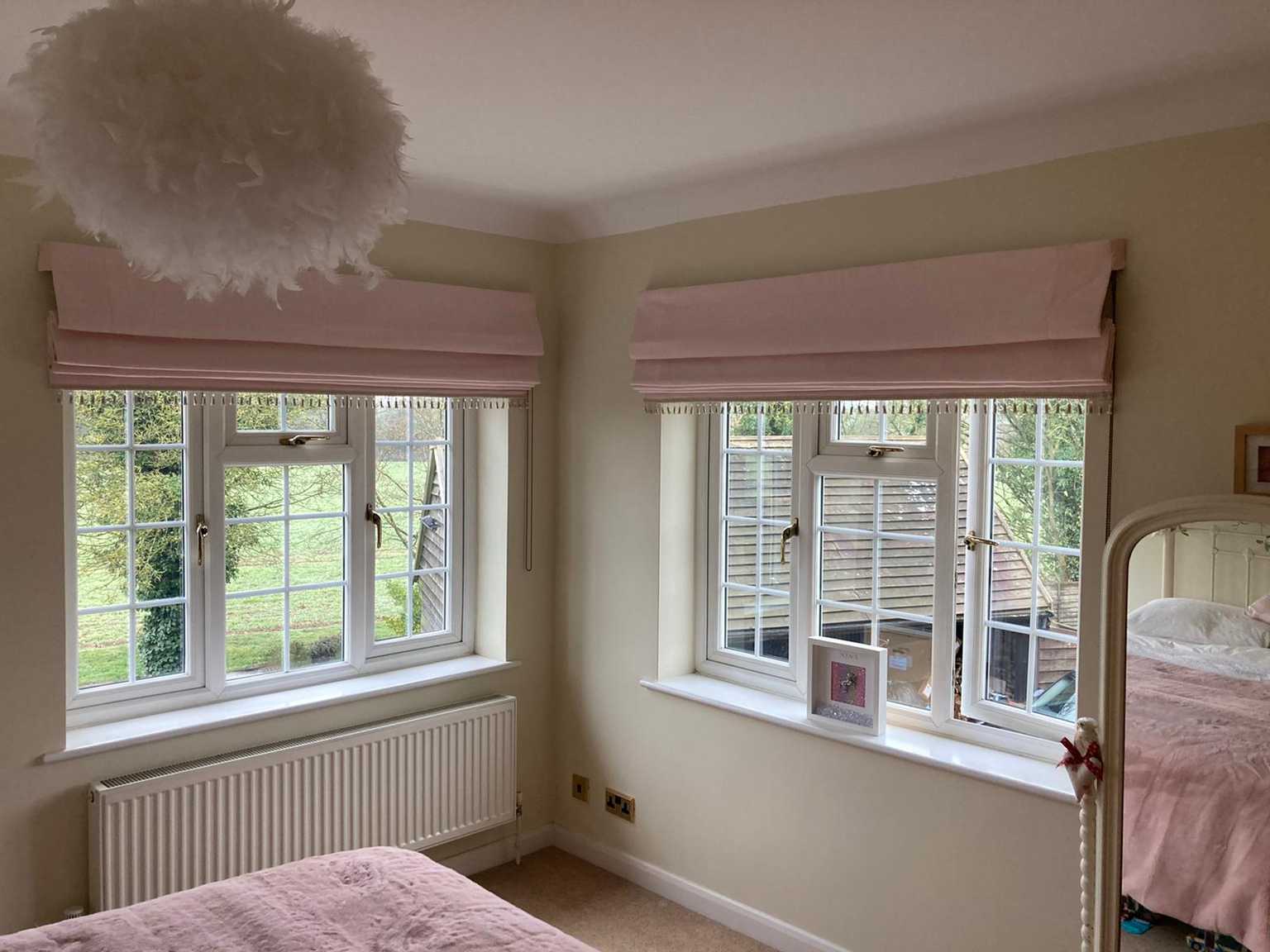 Little girls pale pink roman blinds with bobble trim